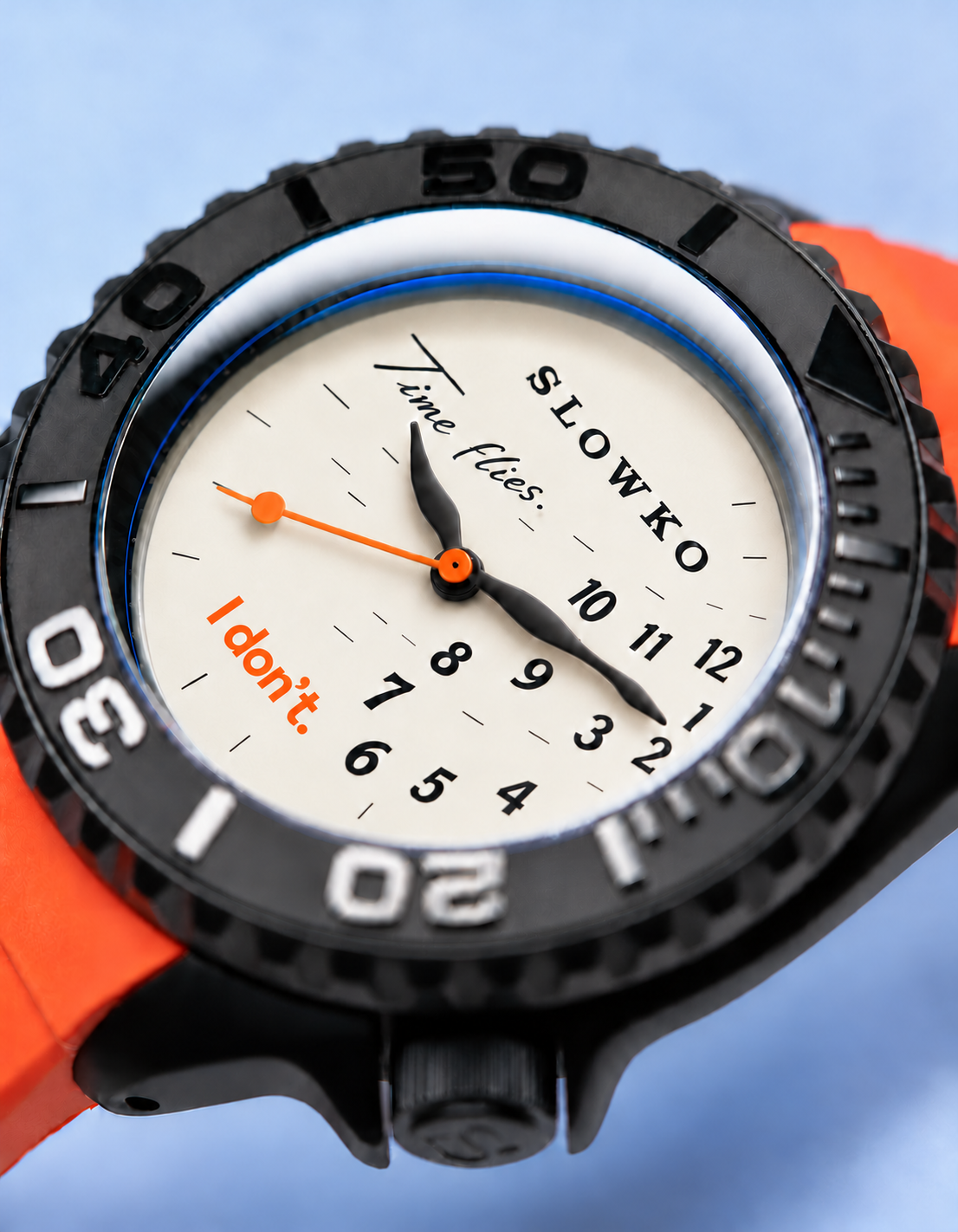 Close-up of the SLOWKO cream dial, curved black hands and orange seconds hand.